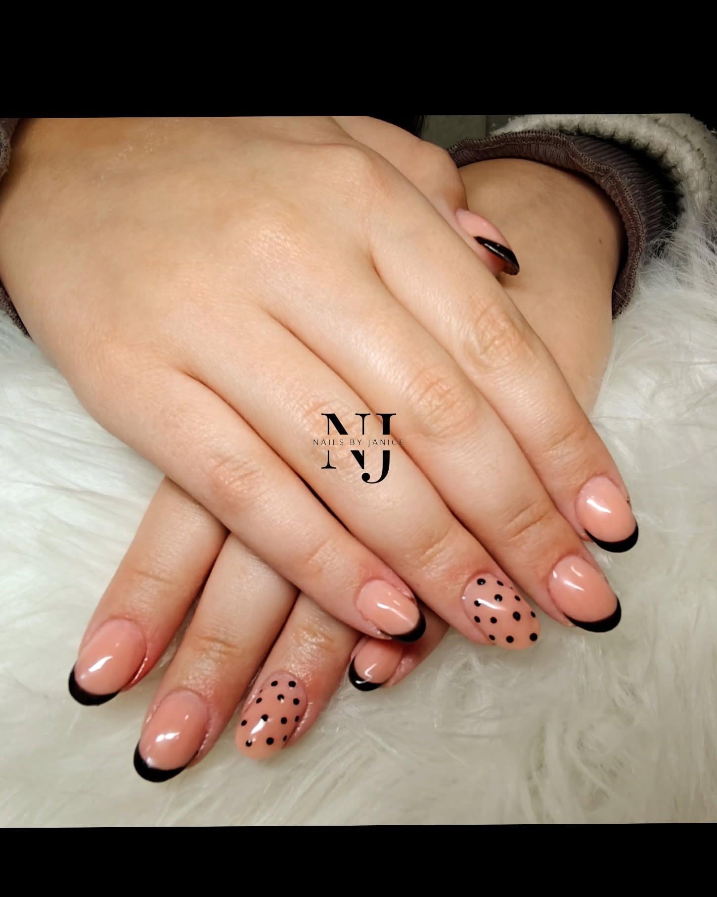 Nude nails with black French tips and polka dot accents
